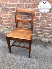 an old wooden chair in front of a brick wall