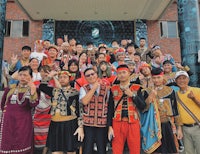 a group of people posing in front of a building