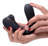 a woman's hand holding a black vibrating toy