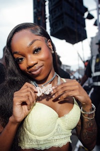 a woman in a yellow bra posing in front of a crowd