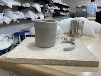 a ceramic mug sitting on a table in a workshop