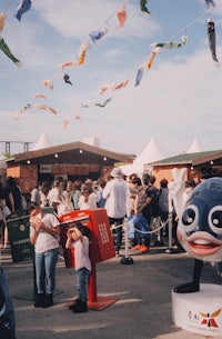 a group of people standing near a statue of a fish