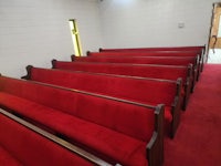 a row of red pews in a church