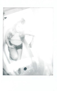 a black and white photo of a woman in a bathtub