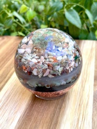 a glass ball filled with rocks and pebbles on top of a wooden table