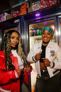 two women standing in front of a refrigerator