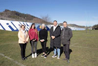 a group of people standing in front of a large field