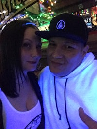 a man and woman posing for a photo in a bar
