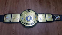 a wwe championship belt on a wooden floor