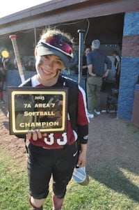 a softball player holding up a plaque