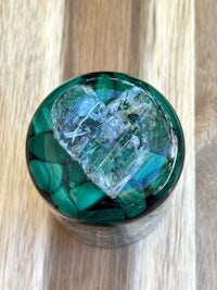 a heart shaped glass box with a tiger's eye stone in it