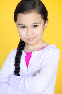 a young girl posing in front of a yellow background