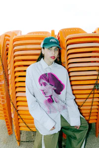 a woman posing in front of a group of orange chairs