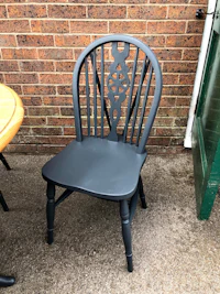 a black chair and table outside of a brick wall