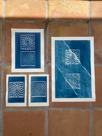 four blue ink prints on a tiled floor