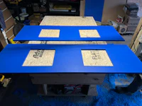 two blue pieces of wood on a table in a workshop