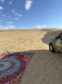 a car is parked in the sand dunes