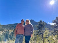 a man and woman standing in front of a mountain