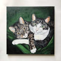 a painting of two cats laying on a green cloth