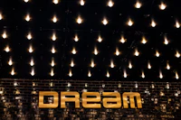 a sign that says dream on a brick wall