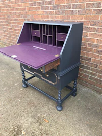 a purple desk with drawers on it