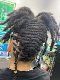 the back of a person with dreadlocks in a salon