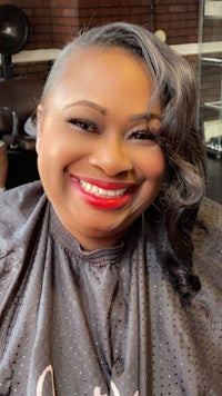 a woman smiling in a hair salon