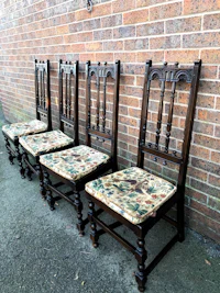 a set of four wooden chairs with floral upholstered seats
