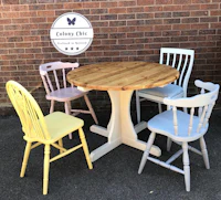 four chairs and a table in front of a brick wall