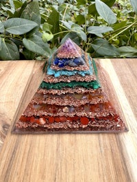 a pyramid made of colored stones on top of a wooden table