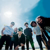 a group of people posing in front of the sun