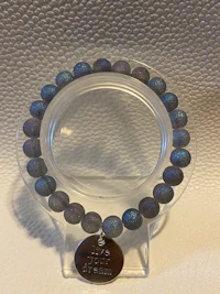 a bracelet with blue and purple beads on a white surface
