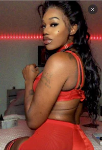 a woman in red lingerie posing on a bed