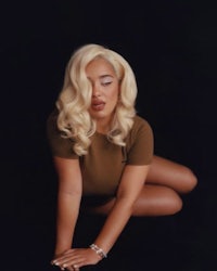 a blonde woman posing on a black background