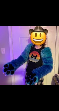 a woman wearing a blue furry t - shirt with a smiley face on it