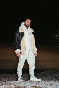 a man in a white jacket standing in the snow
