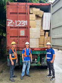 three men standing in front of a truck with boxes