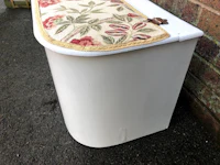 a white trash can with a floral cover on it