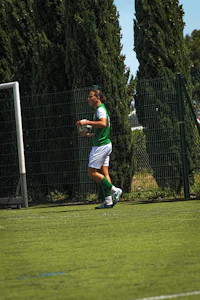 a woman playing soccer on a green field