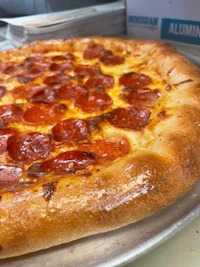 a pepperoni pizza on a metal pan
