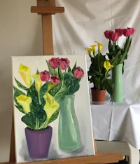 a painting of flowers in vases on an easel