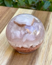 a rose quartz sphere sitting on top of a wooden table