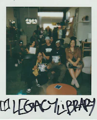a group of people posing in front of a polaroid camera