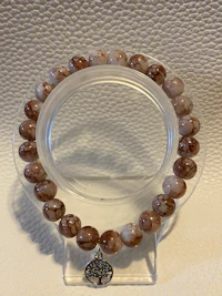 a brown and white beaded bracelet on a white surface