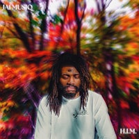 a man with dreadlocks sitting in the woods
