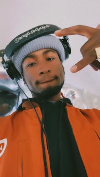a man wearing headphones and a beanie posing for the camera