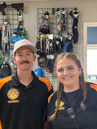 two people standing in front of a display of ski gear