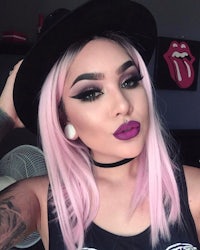 a woman with pink hair and a black hat