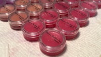 a group of lip balms in jars on a table