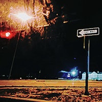 a street sign on a pole at night